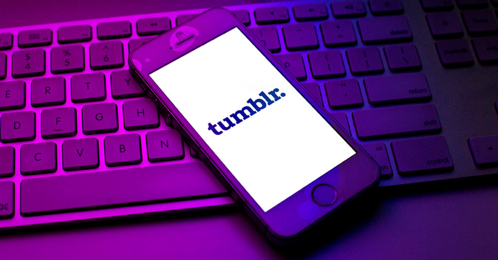 Tumblr open on a phone on a purple-lit keyboard