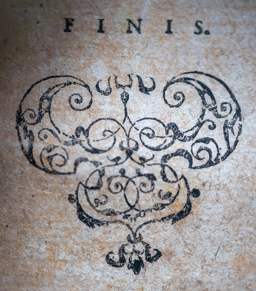 Finis stamp with floral decoration on old parchment - Photo by Gabriella Clare Marino on Unsplash - How to write a story resolution