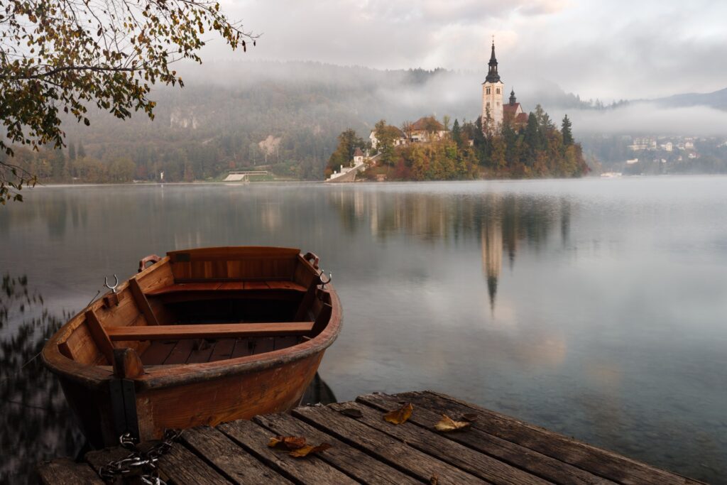 Boat on lake with small island - craft the perfect story setting - photo by artem sapegin on Unsplash