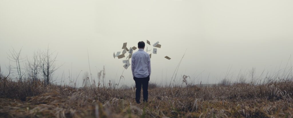 Man surrounded by floating envelopes - subtext - Photo by Jake Melara on Unsplash