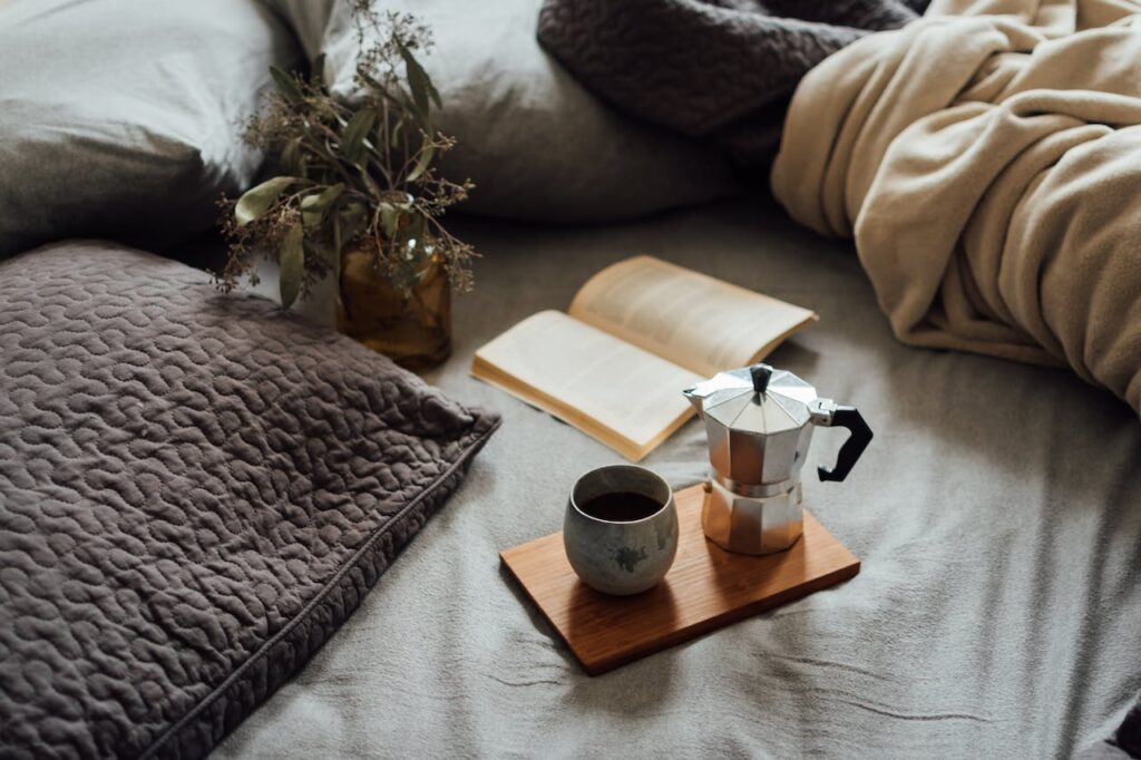 Person reading a story resolution with coffee in bed - Photo by Daniela Constantini for Pexels